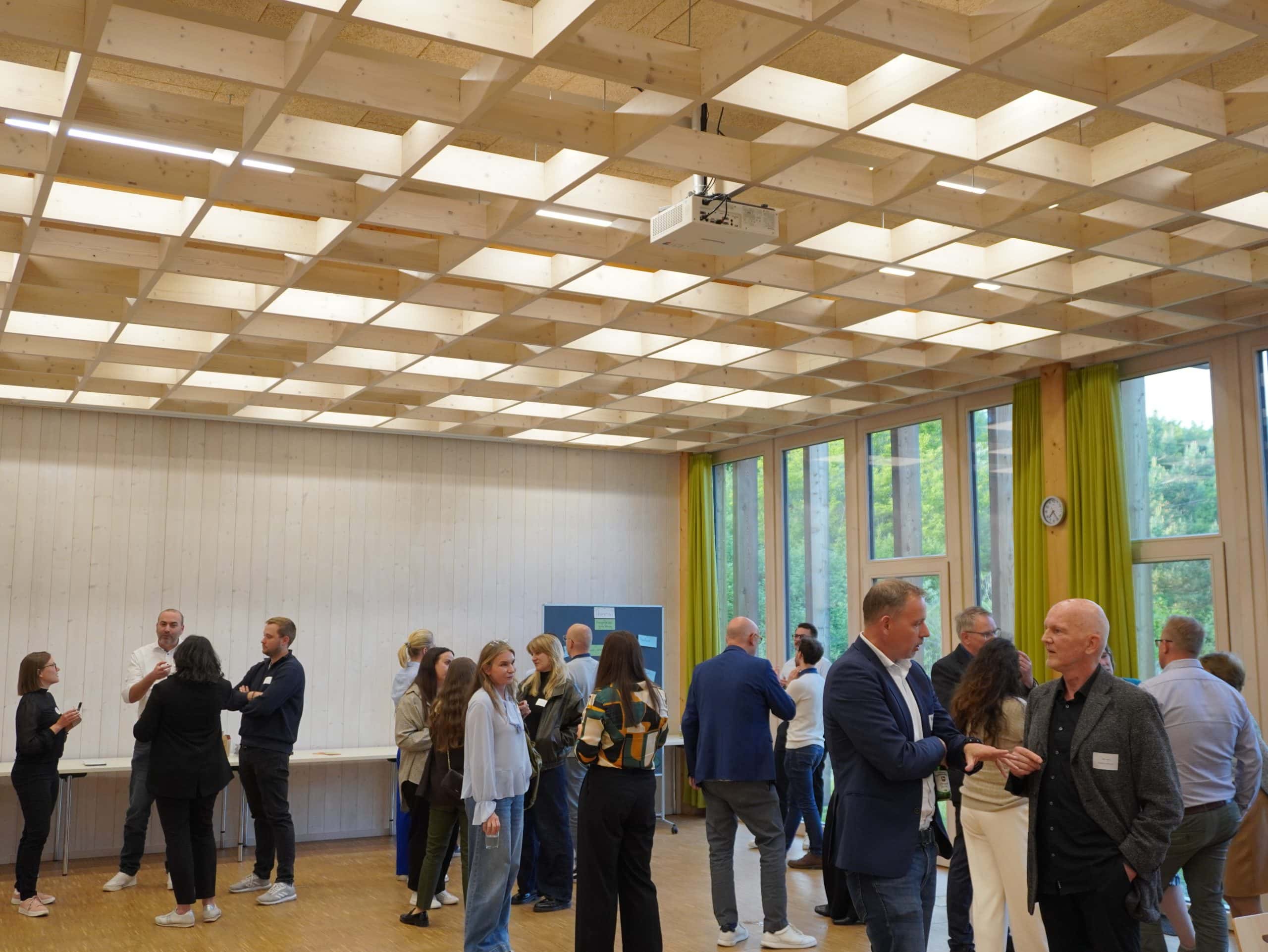 Blick auf Teilnehmende des Innovation Talks Augsburg, die sich in Kleingruppen unterhalten