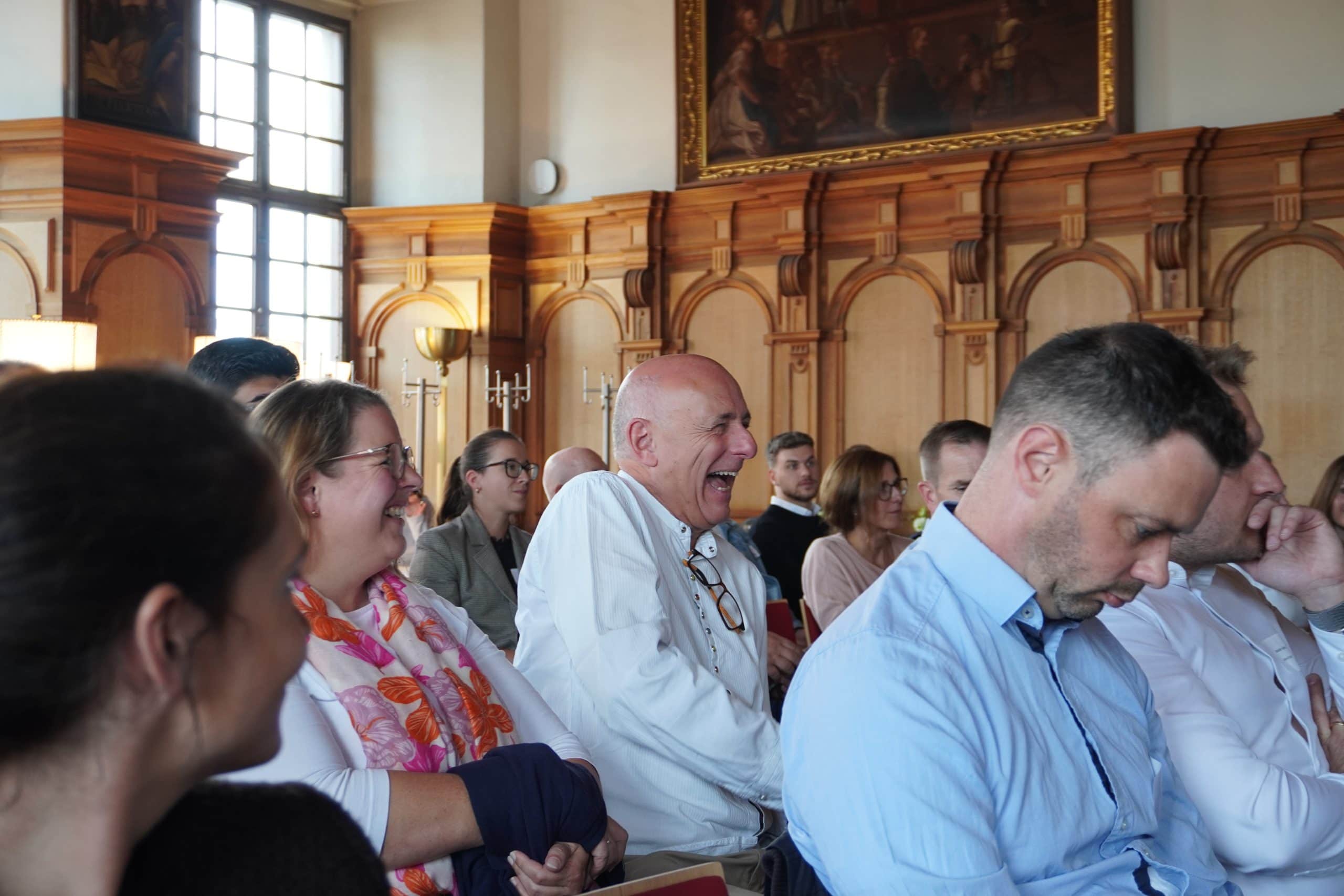 Teilnehmende des Kick-offs lachen gemeinsam