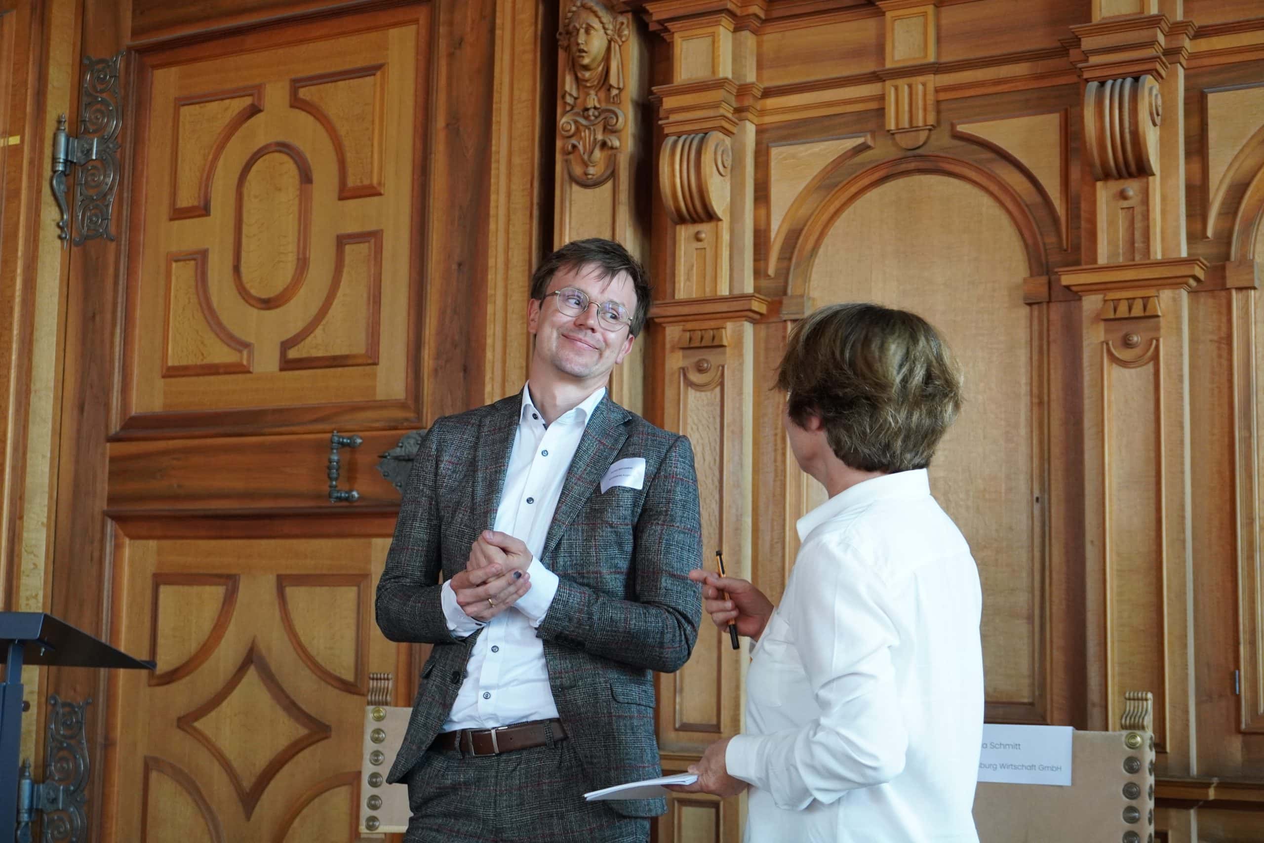 Simone Schönfeld und ein Teilnehmer der Podiumsdiskussion im Gespräch