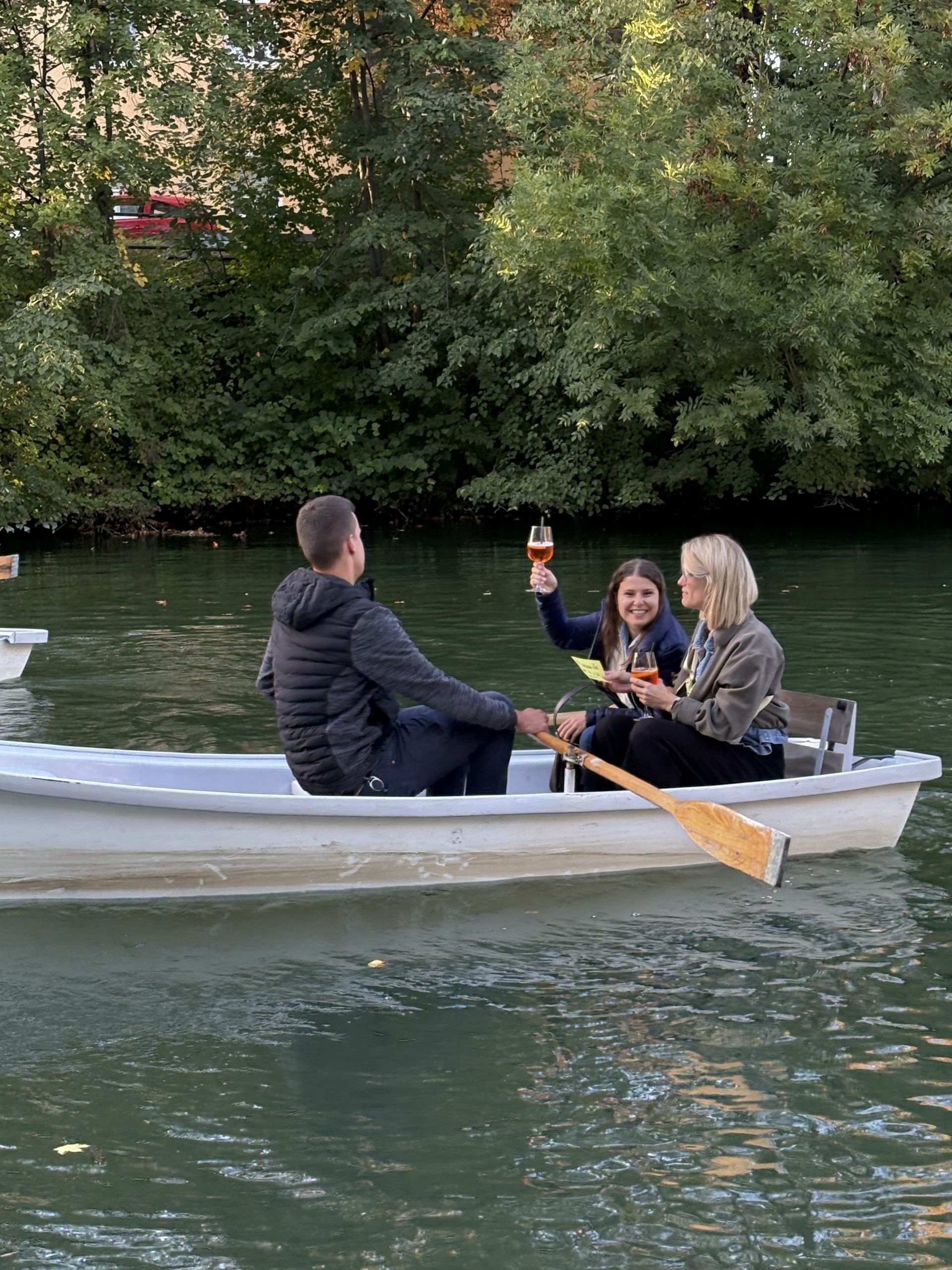Eine Teilnehmerin prostet aus dem Kahn zu, beim Abschluss des 15. Cross Mentoring Augsburg